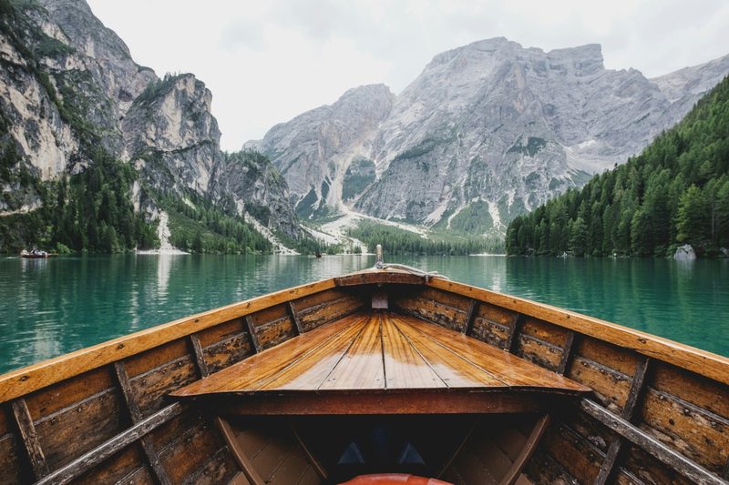 First-person view from a wooden boat on a mountain lake